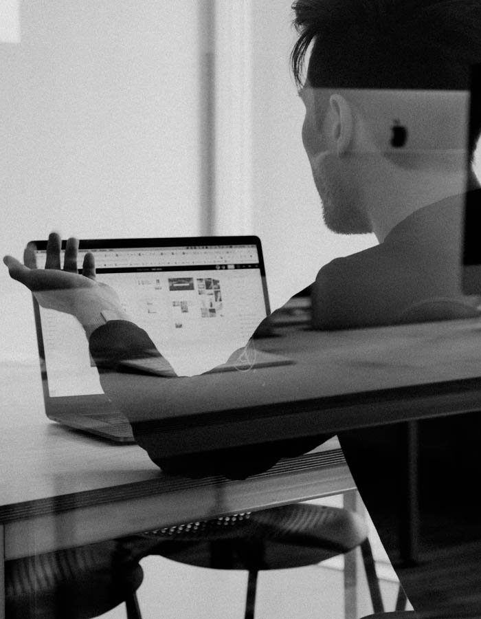 consumer using a laptop computer in a modern office setting doing product and service research for consumer advice black and white stock photography